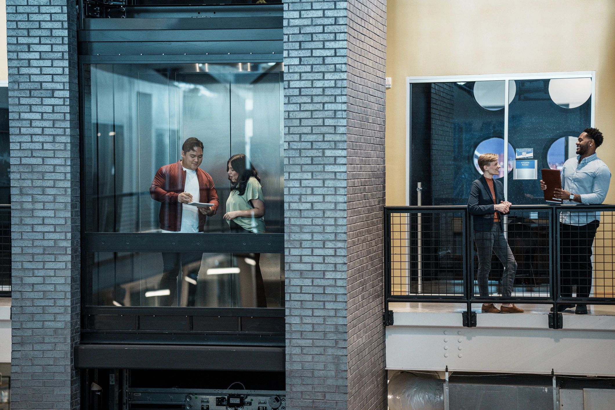 Colleagues chatting in a contemporary office hallway